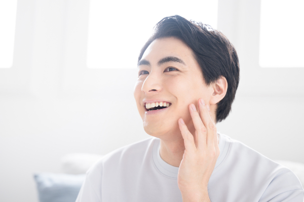マウスピース矯正で出っ歯を治して笑顔を見せる男性