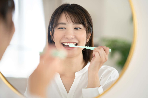 マウスピース矯正中の虫歯を予防する為に食後に歯みがきをする女性
