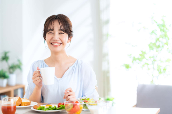 マウスピース矯正をした綺麗な歯並びで食事を楽しむ女性