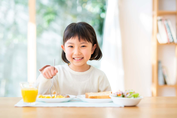 歯肉炎を予防して笑顔で食事をする子ども