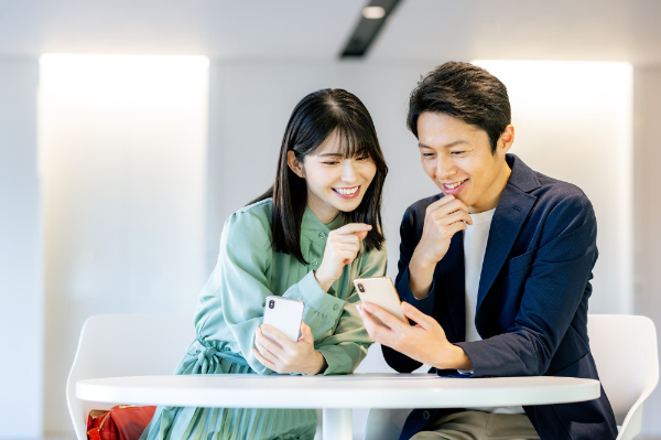 カフェでスマホを楽しそうに見ているカップル