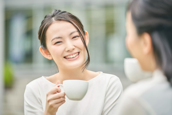 すきっ歯を矯正した女性が友人とカフェでおしゃべりを楽しんでいるイメージ